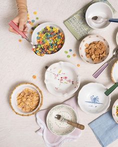 a table topped with bowls and plates filled with cereal