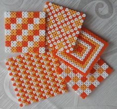 three orange and white coasters sitting on top of a table