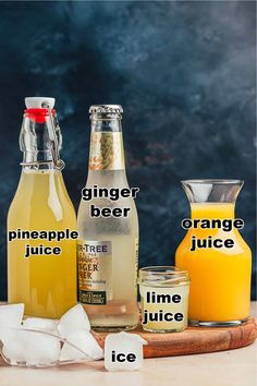 the ingredients for ginger beer are displayed on a cutting board with an orange juice and ice cubes