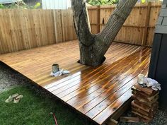 a wooden deck in front of a tree