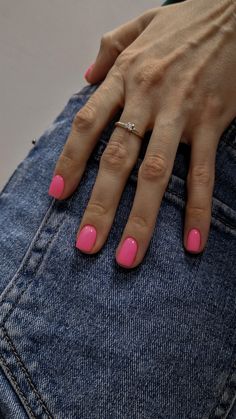 a woman's hand with pink nail polish on her nails and jeans pocketed in