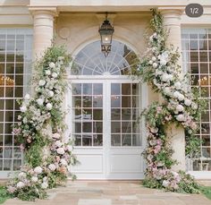 an entrance to a building decorated with flowers and greenery for a wedding or reception