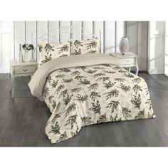 a bed with a white and green comforter on top of it next to a night stand