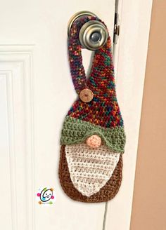 a crocheted door hanger with a gnome face on it's side