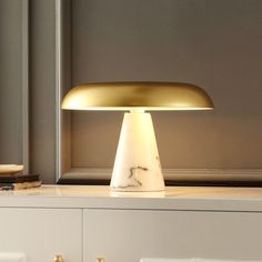 a table lamp sitting on top of a white cabinet