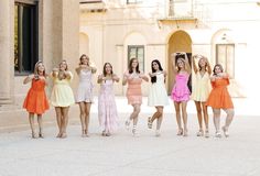 a group of young women standing next to each other in front of a tall building