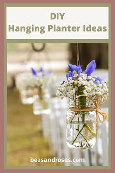 mason jar filled with blue flowers sitting on top of a table next to white chairs