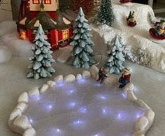 a christmas scene with snow covered trees and lights on the ground in front of a house