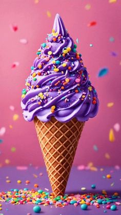 an ice cream cone with purple frosting and sprinkles