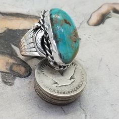 Navajo Sterling Silver and King Manassa Turquoise Ring Very nice King Manassa Turquoise Stone in wonderful condition, and an excellent finish.  There are no breaks or damage to the stone. The cab is set in a smooth bezel setting.  Below the bezel is a twisted wire accent.  The shank is two prong and a shield covering on both side. On top of the shields are grape leavesCondition is very good  - Cab Condition - Excellent (Gemstone Quality)Cab - 1-1/8" x 5/8" Hallmarks -  None Weight - 14.2 gramsSi Southwestern Style Turquoise Ring With Patina, Western Style Turquoise Ring, Western Style Untreated Turquoise Ring, Western Style Natural Turquoise Ring, Untreated Western Turquoise Ring, Untreated Western Style Turquoise Ring, Silver Turquoise Cabochon Ring, Big Finger, Collectible Silver Turquoise Cabochon Ring