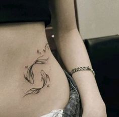 a woman's stomach with a fish tattoo on her belly and the bottom part of her lower back