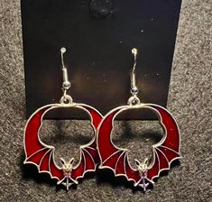 "this listing is for some awesome Halloween earrings, several styles to choose from. Red Winged Bats, Coffins with Spiders, Coffin with fangs and Bite Me charm, Red Spiders or silver ghosts. All these styles are very cute and perfect for an addition to your costume or to wear all season long. Lightweight and have stainless steel ear wire, Sizes are between 1 1/2\" and 2\" in length.   Make your choice in variations" Halloween Fantasy Earrings For Pierced Ears, Fantasy Halloween Earrings For Pierced Ears, Nickel-free Red Themed Jewelry, Nickel-free Themed Red Jewelry, Themed Red Earrings, Themed Red Nickel-free Jewelry, Red Punk Earrings For Gifts, Red Novelty Jewelry For Halloween, Halloween Fantasy Dangle Earrings