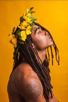 a man with dreadlocks and yellow flowers on his head