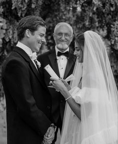 the bride and groom are smiling at each other as they hold hands during their wedding ceremony