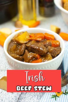 a white bowl filled with beef stew and carrots on top of a blue towel