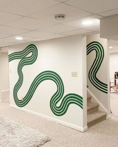 an empty room with stairs painted on the wall and carpeted flooring in front of it