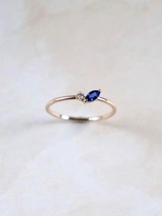 Flower inspired petal ring. Whimsical and dainty. The ring is accompanied by a beautiful blue sapphire in marquise cut and a round brilliant diamond. Blue sapphire represents wisdom, everlasting love and it is a September birthstone. 1 x Blue sapphire in marquise cut. Measures 6x3 mm. 1 x Round brilliant diamond sizes 1.5 mm. VS quality. 1.3 mm ring band. Made of 10K solid gold. Tiny Marquise Ring, Dainty Sapphire Ring, Blue Sapphire Marquise Ring, Vintage Blue Sapphire Ring, Tiny Diamond Necklace, Petal Ring, Graduation Ring, Marquise Sapphire, Blue Sapphire Jewelry