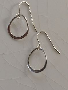 Simple and modern, Small Sterling Silver Teardrop/Pear Earrings  Each handmade earring comprises a flat, solid and beautifully rounded Sterling Silver Pear/Drop-Shaped Hoop which is suspended from a Sterling Silver French Hook Ear Wire.   These earrings are so pretty and there is movement and swing as the pendants move on the ear wire.  Measurements are 12x15 for the drops and the total length of the earring from the base of the earring to the top of the ear wire (the dangle) is approx. 22-24 mm.    Please note:  Photos are enlarged to show detail. Please see the dimensions in the description above for accurate measurements of these earrings.  I am totally committed to 100% satisfaction on your part and ask that you contact me at any point with any questions or special requests, but especi Everyday Simple Drop Earrings, Simple Teardrop Earrings For Pierced Ears, Modern Oval Teardrop Earrings For Pierced Ears, Modern Small Hoop Teardrop Earrings For Pierced Ears, Everyday Silver Hoop Earrings With French Hook, Everyday Minimalist Teardrop Dangle Earrings, Silver Teardrop Hoop Earrings With French Hook, Simple Silver Teardrop Earrings, Modern Hoop Earrings With French Hook