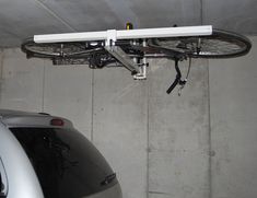 there is a bike hanging from the ceiling in this garage with no one around it