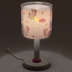 a lamp that is sitting on top of a table with a pink base and white lampshade