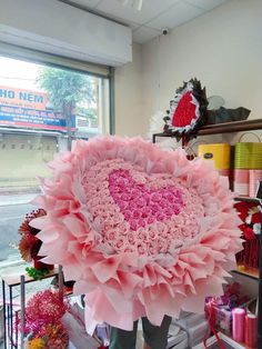 a large pink flower in the shape of a heart sitting on top of a table