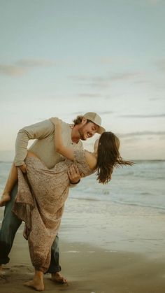 a man carrying a woman on his back at the beach