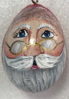 a glass ornament with a man's face painted on it