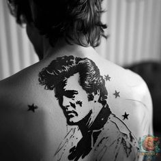 the back of a man's neck with a tattoo on his left shoulder and stars around it