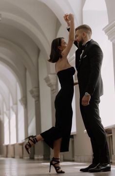 a man and woman in formal wear dancing