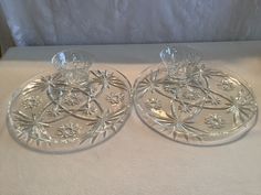 two clear glass dishes sitting on top of a white tablecloth covered table next to each other