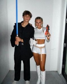 a man and woman dressed up as star wars characters holding lightsabens in their hands