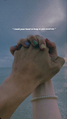 two hands holding each other in front of the ocean with a quote above them that reads, i hold your hand as long as you need me