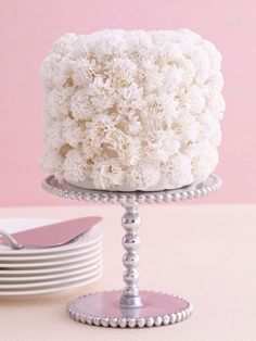 a white cake sitting on top of a table next to plates and utensils