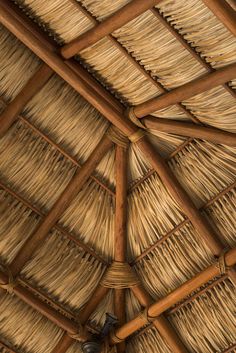 the inside of a straw hut with thatched roof and wooden poles on it's sides