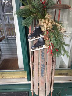 an old sled with christmas decorations and ice skates hanging from it's side