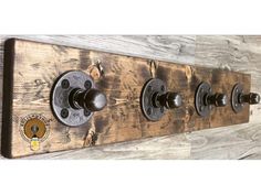 a wooden coat rack with four knobs on it