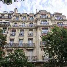 an apartment building with balconies and balconyes on the top floor, surrounded by trees