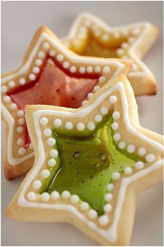 three decorated cookies sitting on top of a white plate with green and red icing