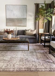 a living room filled with furniture and a painting hanging on the wall over a coffee table