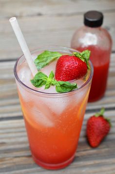 two glasses filled with drinks and strawberries