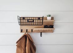 a coat rack with two coats hanging from it's hooks on a white wall