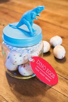 a jar filled with marshmallows and a dinosaur figurine on top