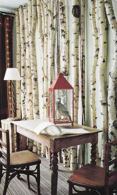 a table with a lamp on top of it next to two chairs and a bench