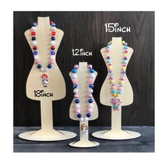 three mannequins with different colored beads on them