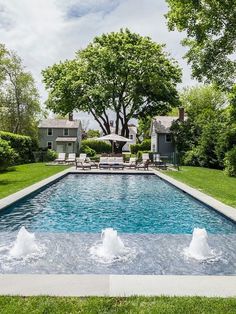 an outdoor swimming pool surrounded by trees and lawn furniture