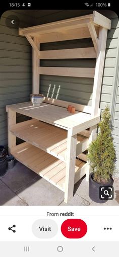 a wooden bench sitting next to a potted plant on top of a cement floor