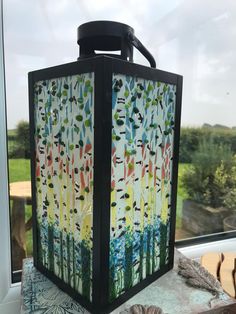 a lantern sitting on top of a table next to a window