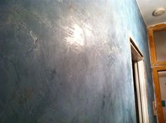 an empty room with blue walls and peeling paint on the wall is pictured in this image