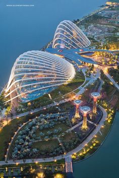 an aerial view of gardens by the bay at night, with lights shining on them