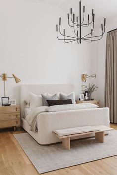 a white bed sitting on top of a wooden floor